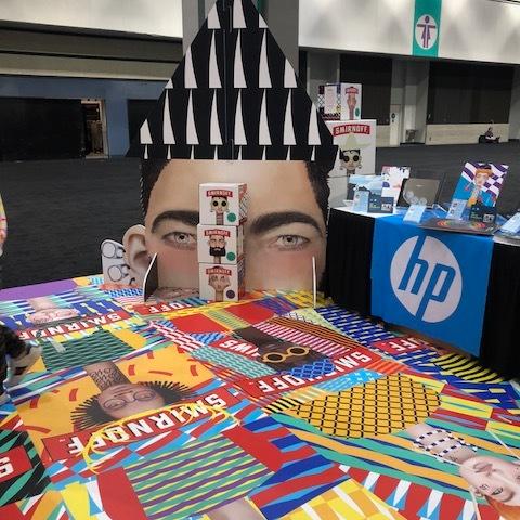 Convention booth showing floor printing, graphics on the table, and graphics on the backwall